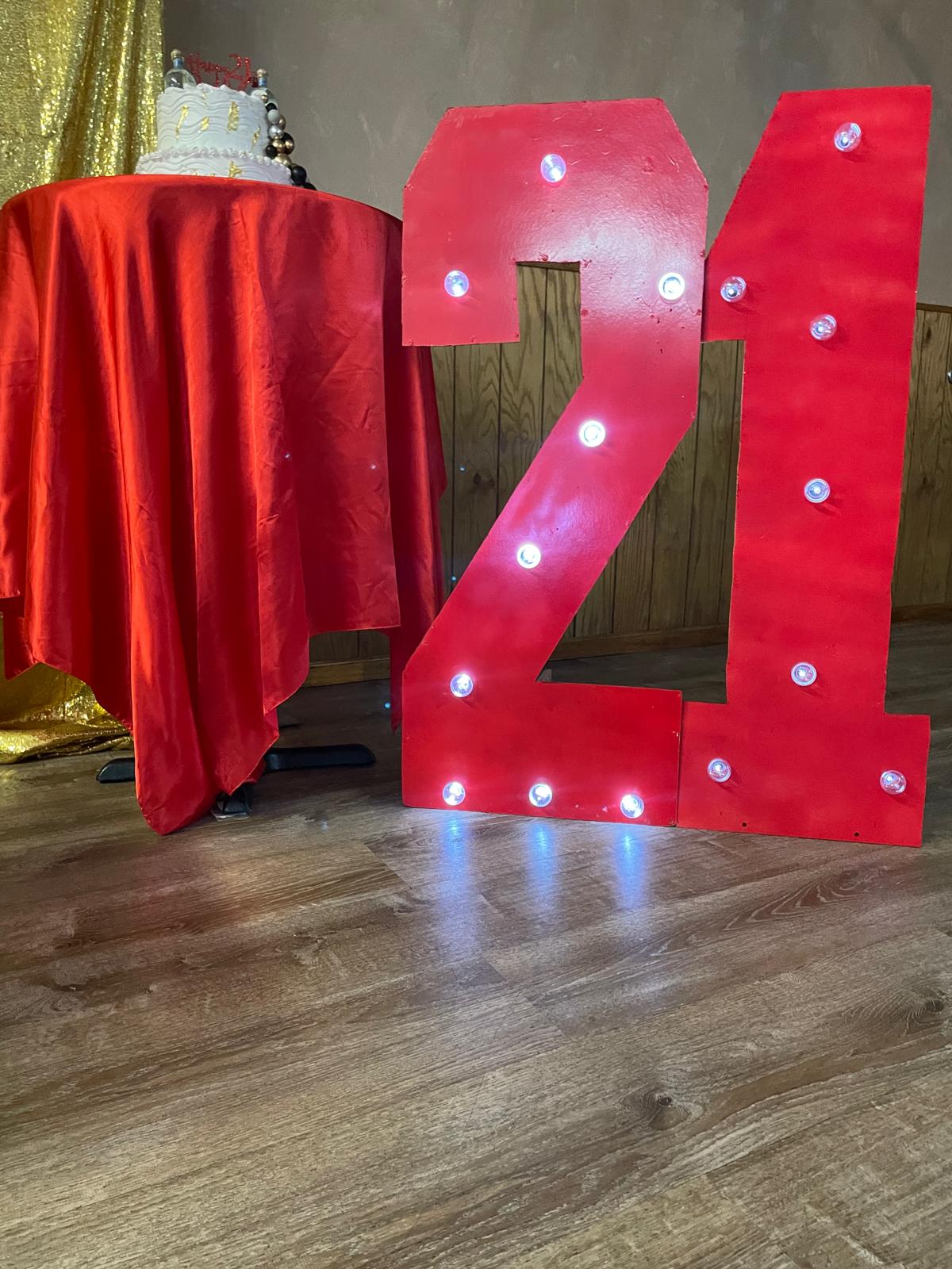 21st birthday marquee numbers with cake