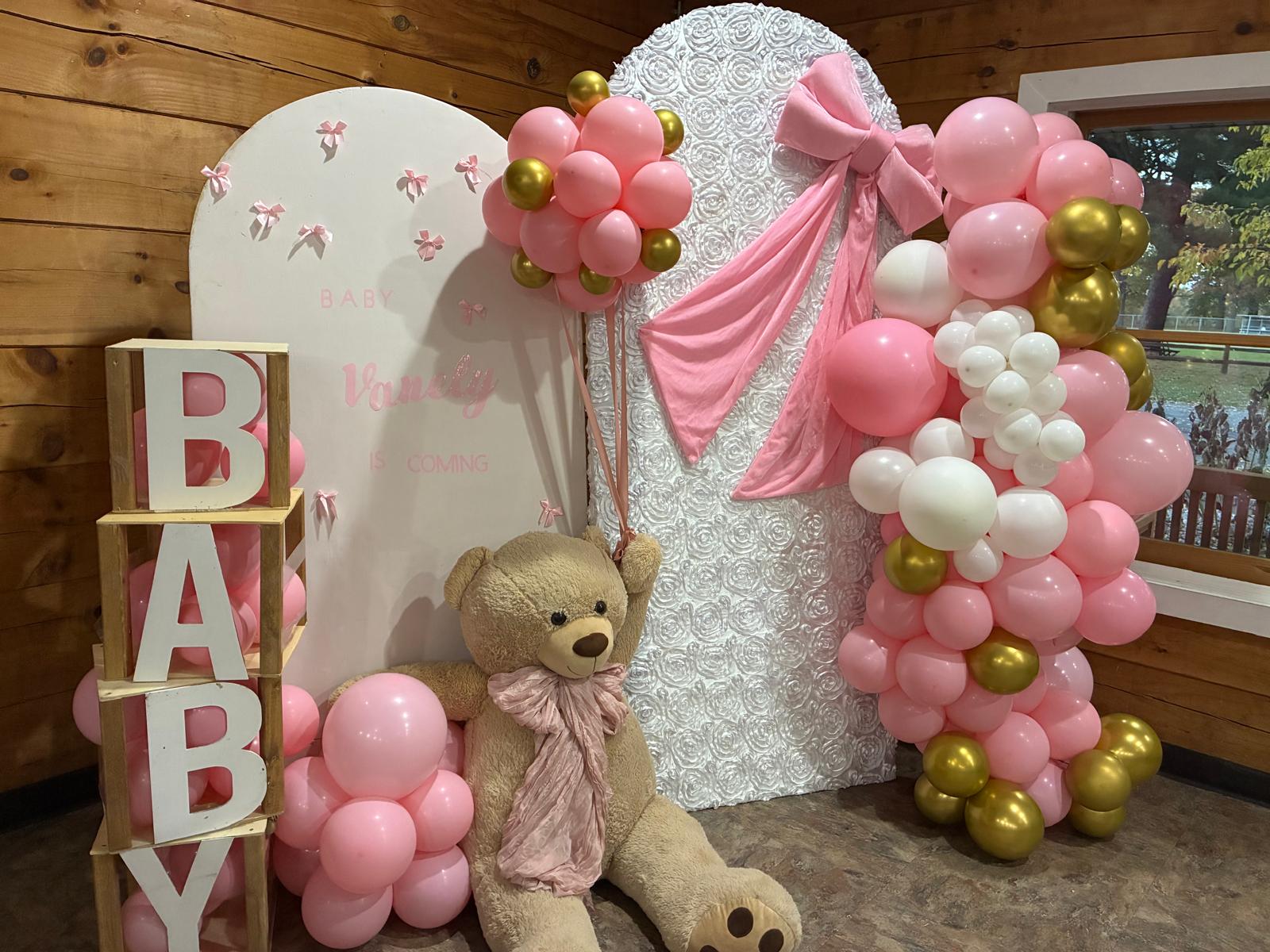 Pink baby shower balloon display with teddy bear